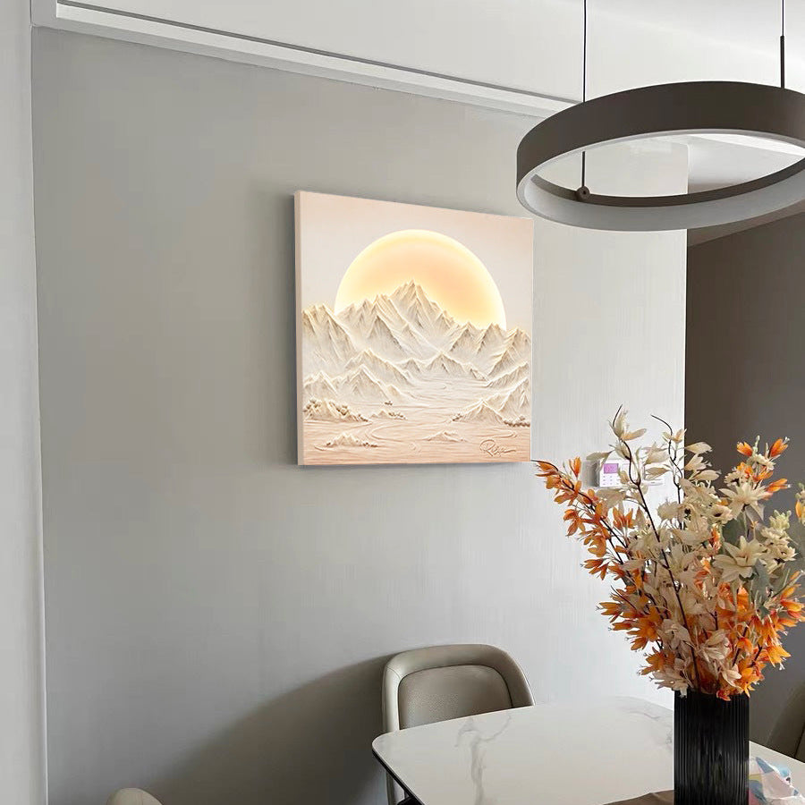 Dining room with a mountain landscape painting on the wall and a table with flowers.