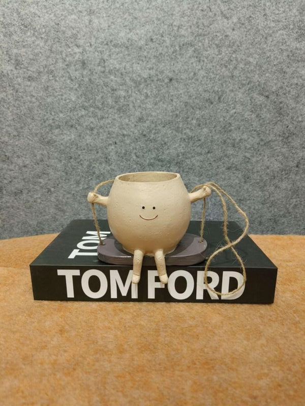 Artifacts Whimsical 'Happy Pot' Figurine with Dangling Legs on Decorative Book Base